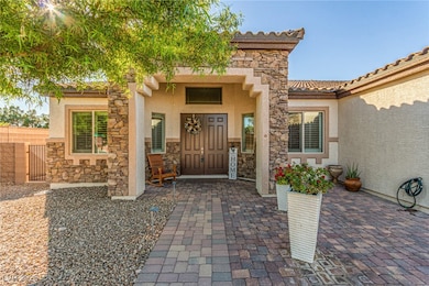 View of exterior entry featuring stone siding, stucco siding, and a tile roof