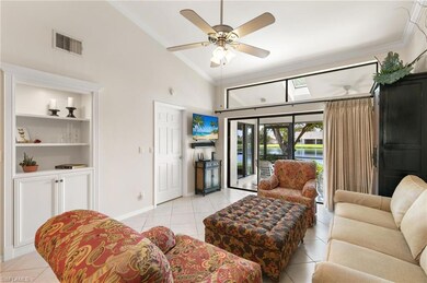 Living area featuring crown molding, a towering ceiling, light tile patterned floors, ceiling fan, and a skylight