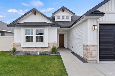 Entrance to property with stone siding, roof with shingles, and board and batten siding