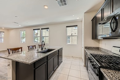 Kitchen featuring black appliances, a sink, light