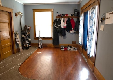 Foyer featuring crown molding, baseboards, and hardwood / wood-style flooring