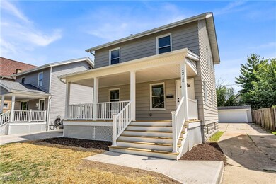 View of front facade with a garage, an outbuilding, and a porch