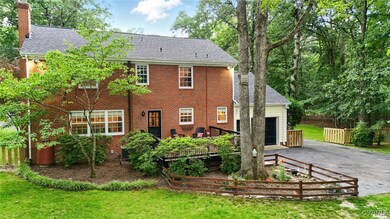 Rear view of house with asphalt driveway, a garage
