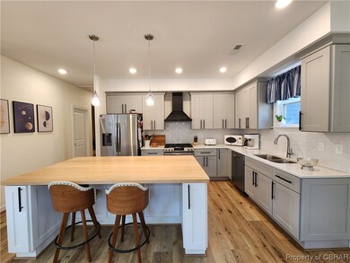 Kitchen featuring wall chimney exhaust hood, a cen