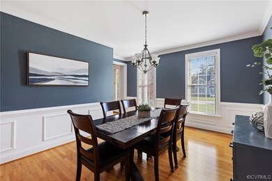 Formal dining room features hardwood floors, chand