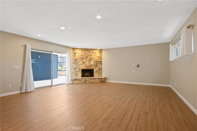 Huge family room offers laminate flooring, corner fireplace, wet bar and sliding door access to patio!