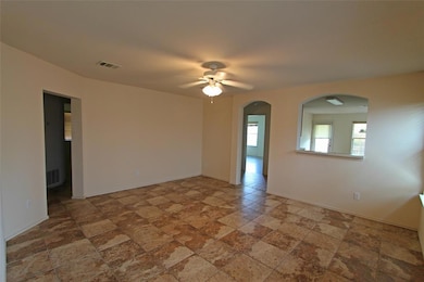 Empty room with arched walkways, ceiling fan, and