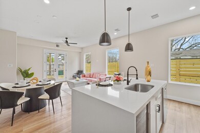 Modern open-concept kitchen and dining area with clean lines, pendant lighting, and a mix of neutral and pastel colors.