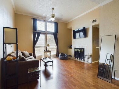 Living room featuring ceiling fan, a textured cei