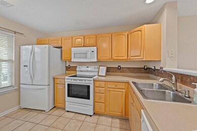 Kitchen with light countertops, white appliances, 