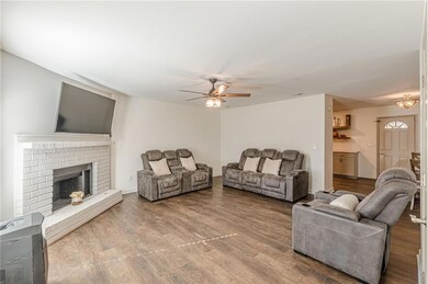 Living area with wood finished floors, a fireplace, and ceiling fan