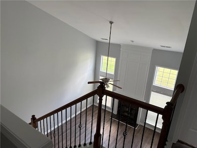 Stairs with a ceiling fan, wood finished floors, a