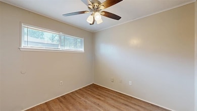 Unfurnished room with wood finished floors, ornamental molding, and ceiling fan