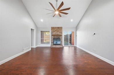 Unfurnished living room featuring high vaulted ceiling, dark wood-type flooring, a fireplace, a ceiling fan, and recessed lighting