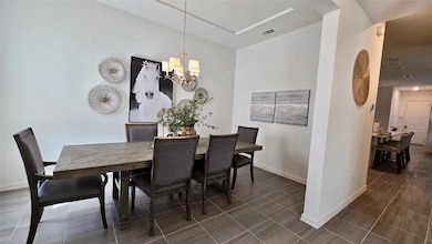 Dining room with a chandelier and tile patterned flooring