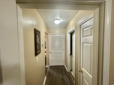 Hallway with dark hardwood / wood-style floors