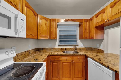 Kitchen offers oak cabinets and white appliances w