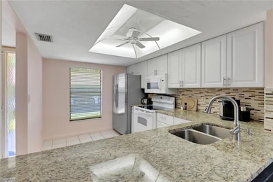 Kitchen featuring a sink, ceiling fan, white appli