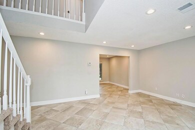 The foyer opens to the formal living area with wonderful tile flooring and soaring ceilings.
