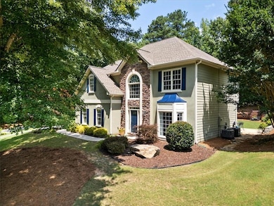 Traditional-style house with stone, a front lawn, and a shingled roof