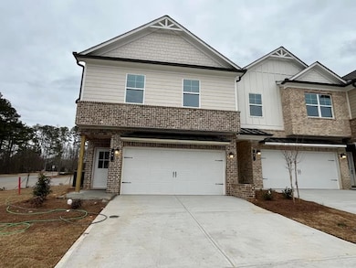 View of front facade featuring a 3-car garage, brick siding, and concrete driveway