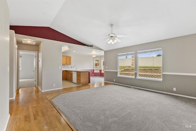 Unfurnished living room with lofted ceiling, light wood-type flooring, and a ceiling fan