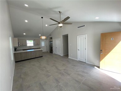 Open concept with living area and Kitchen featuring ceiling fan, hanging light fixtures, high vaulted ceiling, Fan, stainless steel fridge, and light tile floors
