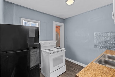 Kitchen with electric range and refrigerator.