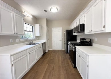 Kitchen featuring visible vents, white cabinets, a