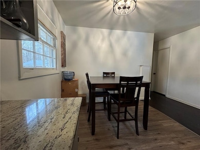 Dining area featuring dark wood-style floors, base