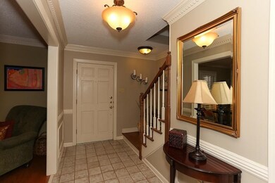 Entry hall with tile floor and updated light fixtu