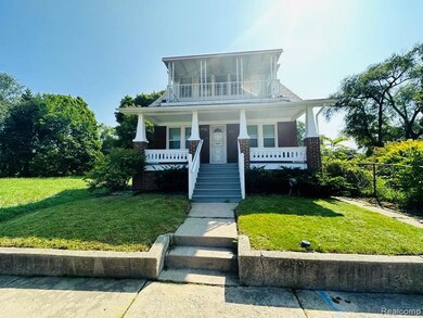 View of front of property with a front yard, a porch, and stairway