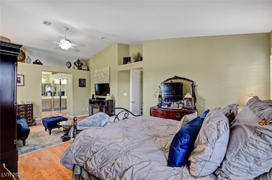 Bedroom with wood finished floors, vaulted ceiling, and ceiling fan