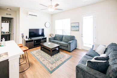 Living area with a wall mounted AC, ceiling fan, 