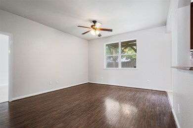 Empty room featuring a ceiling fan and dark wood-type flooring