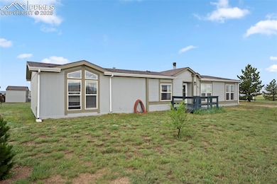 Back of house with a lawn