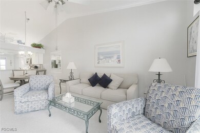 Living area with carpet floors, high vaulted ceiling, and ceiling fan