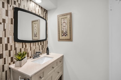 Bathroom featuring vanity and decorative backsplash