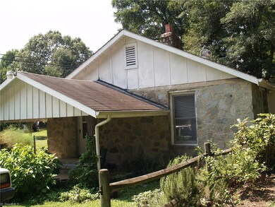 Covered patio with views of herb gardens and backyard.
