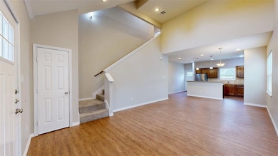 Unfurnished living room featuring stairway, light wood-style floors, high vaulted ceiling, and recessed lighting