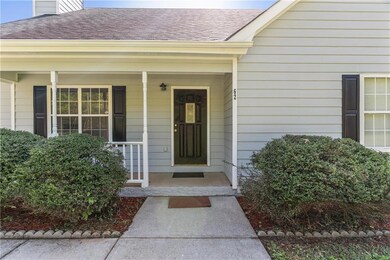 Doorway to property with a shingled roof and cover