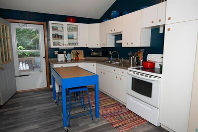Kitchen featuring sink, vaulted ceiling, white cab