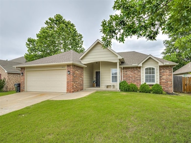 Ranch-style home with a garage, brick siding, driveway, and roof with shingles