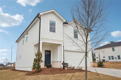 View of front of home with a garage, central AC un