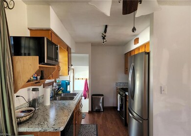 Galley kitchen with refrigerator, gas stove and di