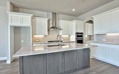Kitchen with wall chimney range hood, double oven