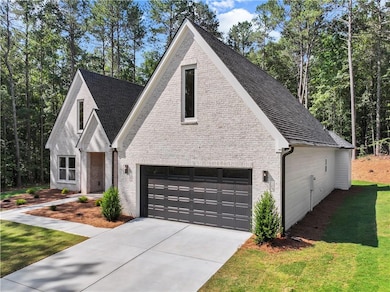 View of front facade featuring brick siding, concrete driveway, a front yard, and a garage