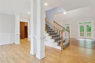 Stairs with visible vents, ornate columns, wood fi