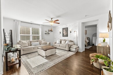 Living room featuring ceiling fan and dark hardwoo