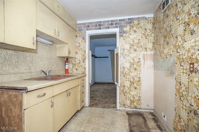 Kitchen with light countertops, light floors, and cream cabinetry
